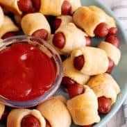 Plate of little smokies pigs in a blanket with ketchup.