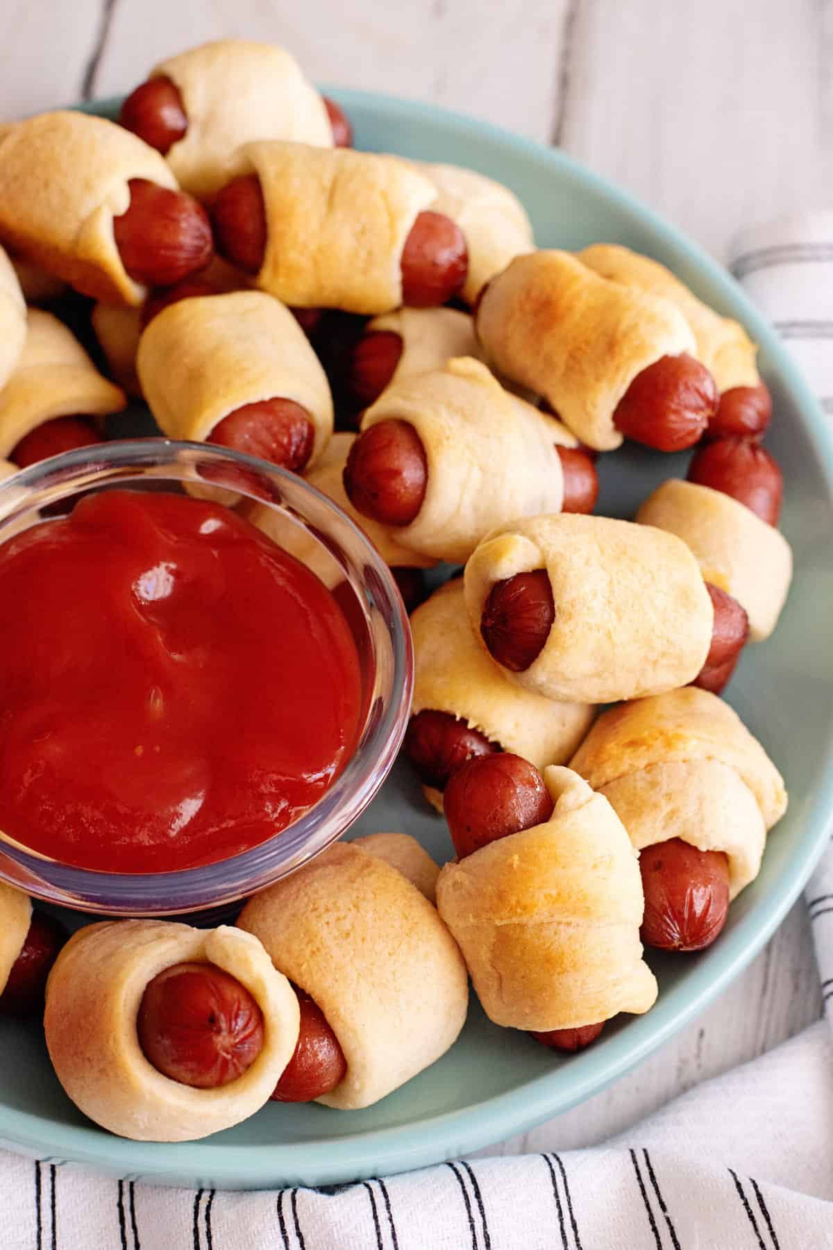 Plate of little smokies pigs in a blanket with ketchup.