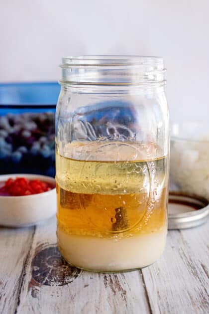 Place sugar, cider vinegar, oil, minced garlic, salt, and pepper in a mason jar.