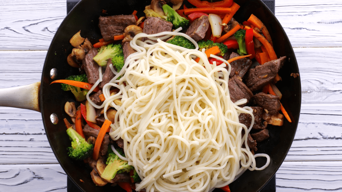Add cooked lo mein noodles to skillet.