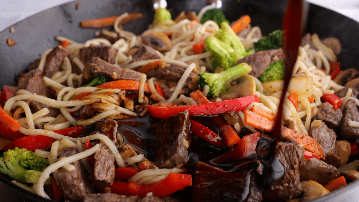 Pour sauce over beef lo mein in skillet.