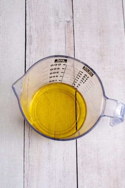 Place 1/4 cup of olive oil in measuring cup.