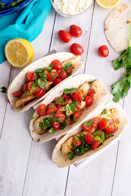 Top each Greek chicken taco with the tomato/parsley mixture.