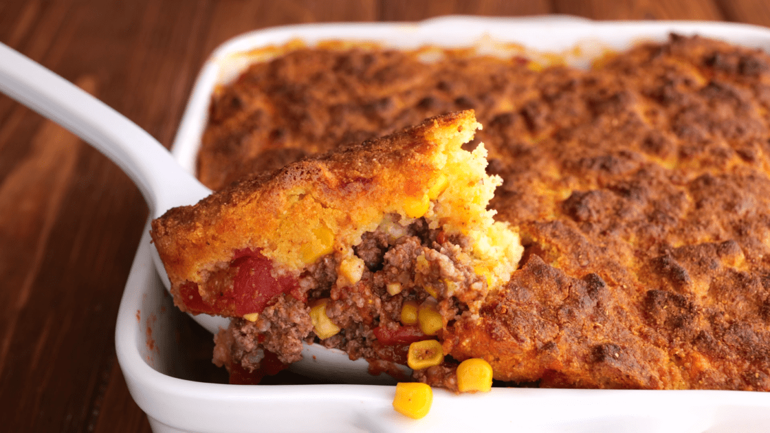 Spatula holding a slice of Mexican cornbread casserole.