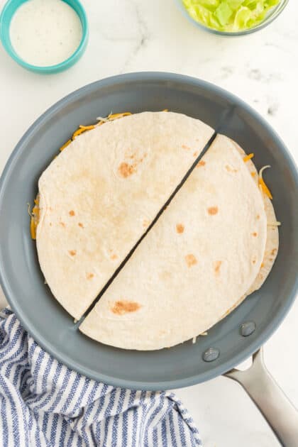 Add 2 folded tortillas to a skillet and brown on both sides.