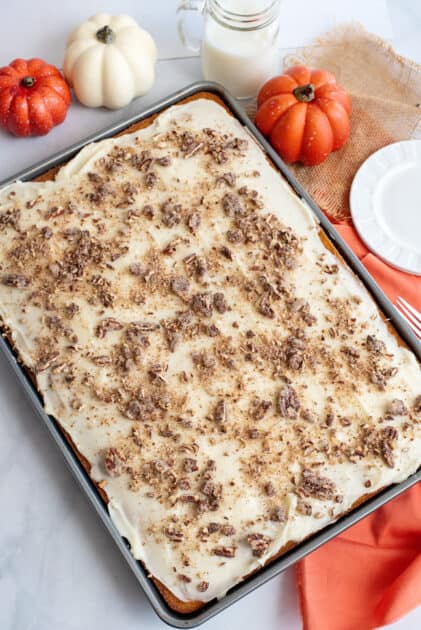 Sprinkle pumpkin bars with cream cheese frosting with cinnamon and candied pecans.