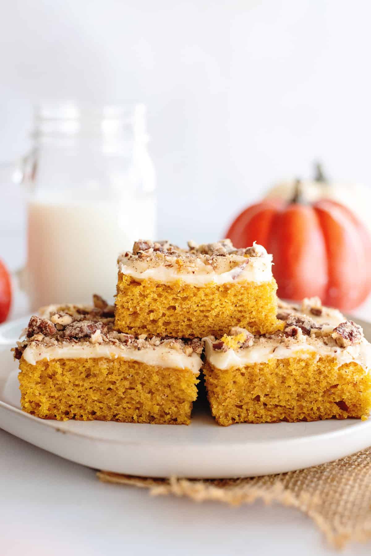 Stack of pumpkin bars with cream cheese frosting.