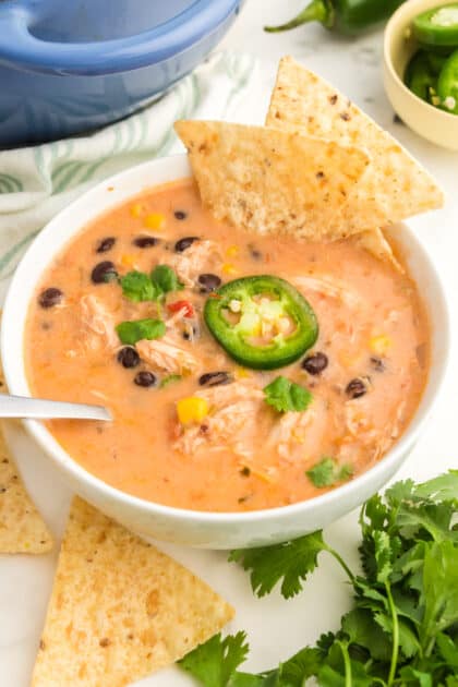 Serve Southwest chicken soup with jalapenos, cilantro, and corn chips.