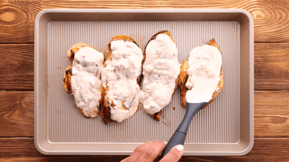 Add sauce to grilled fiesta lime chicken on baking sheet.