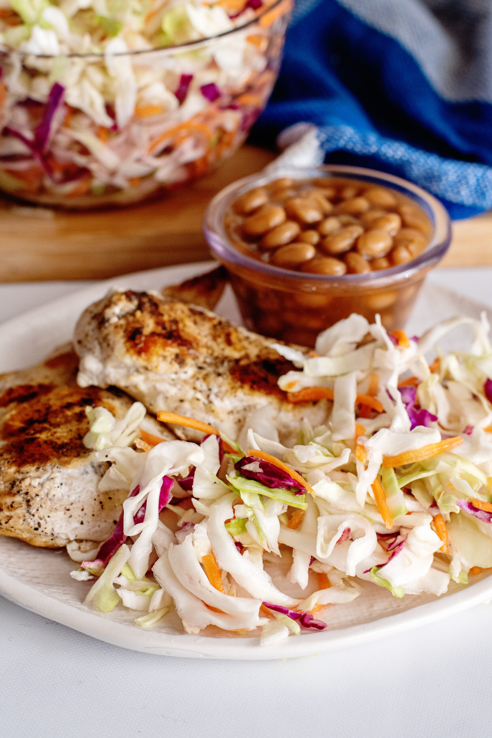 Vinegar slaw on plate with chicken and baked beans.