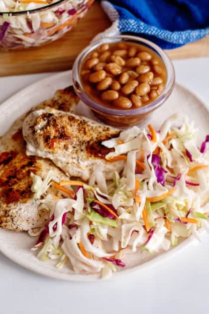 Vinegar slaw on plate with chicken and baked beans.