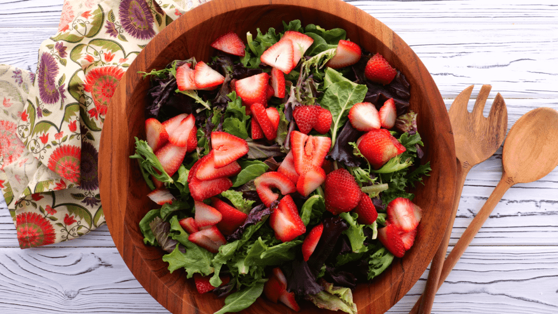 Add strawberries to salad bowl.