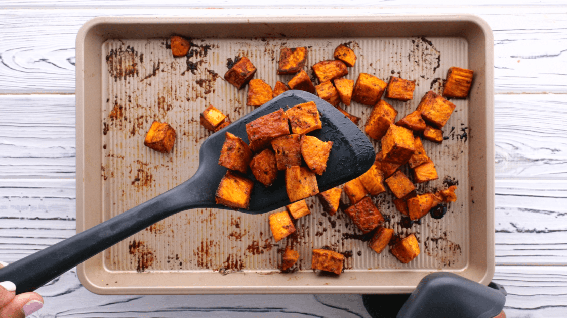 Spatula holding a serving of honey roasted sweet potato.