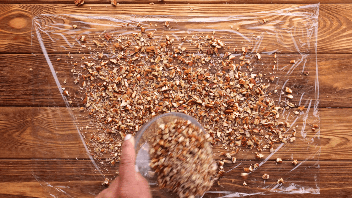 Scatter pecans on top of plastic wrap.