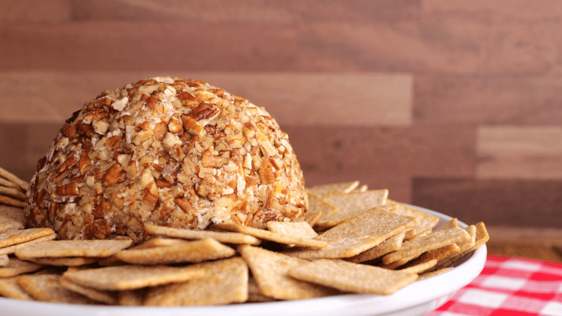 Cheese ball on plate with crackers.