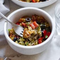 Fork in a bowl of Mediterranean quinoa salad.