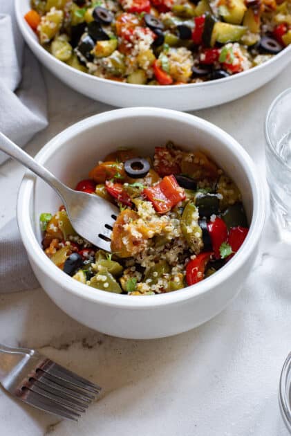 Fork in a bowl of Mediterranean quinoa salad.