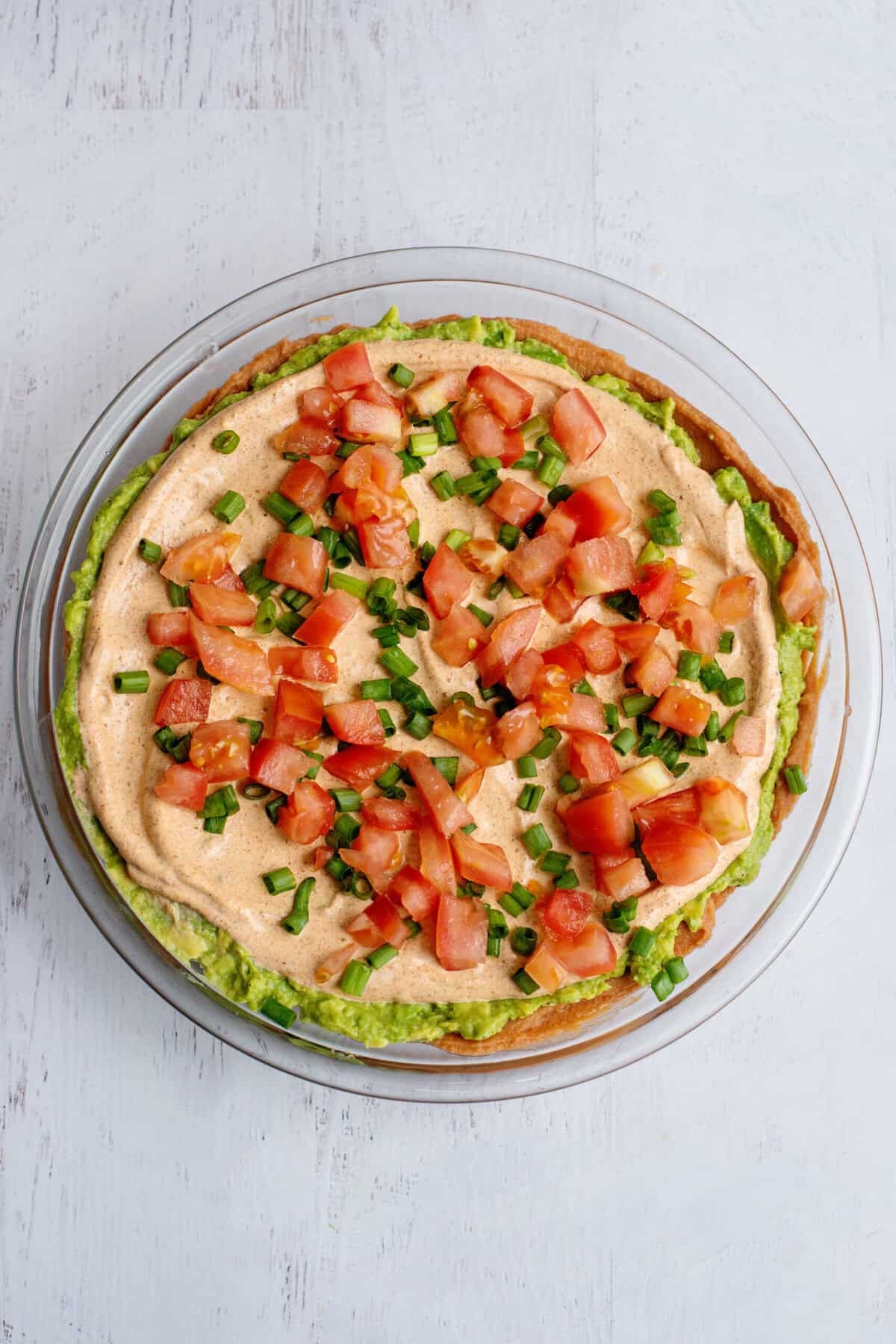 Green onions and diced tomatoes sprinkled over Tex Mex dip.