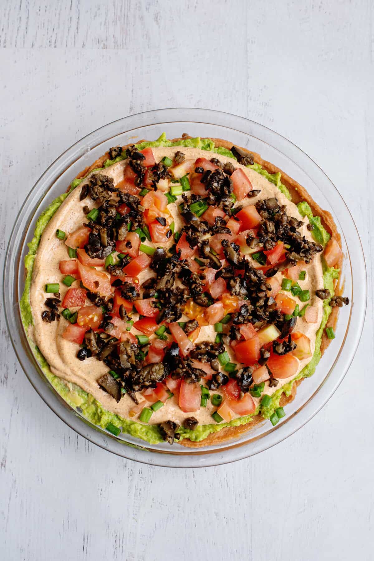 Green onions, diced tomatoes, and black olives sprinkled over Tex Mex dip.