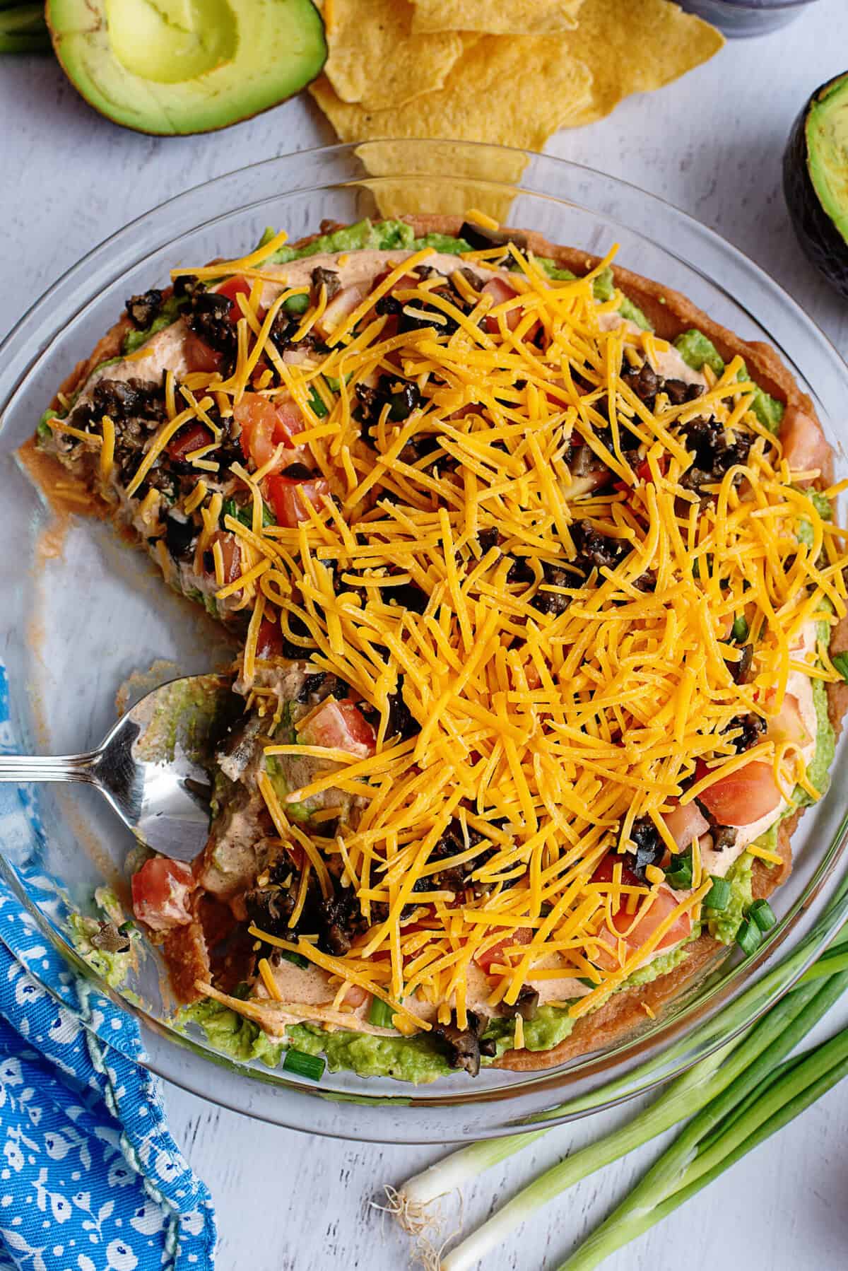 Tex Mex dip with a portion taken out in a glass dish.
