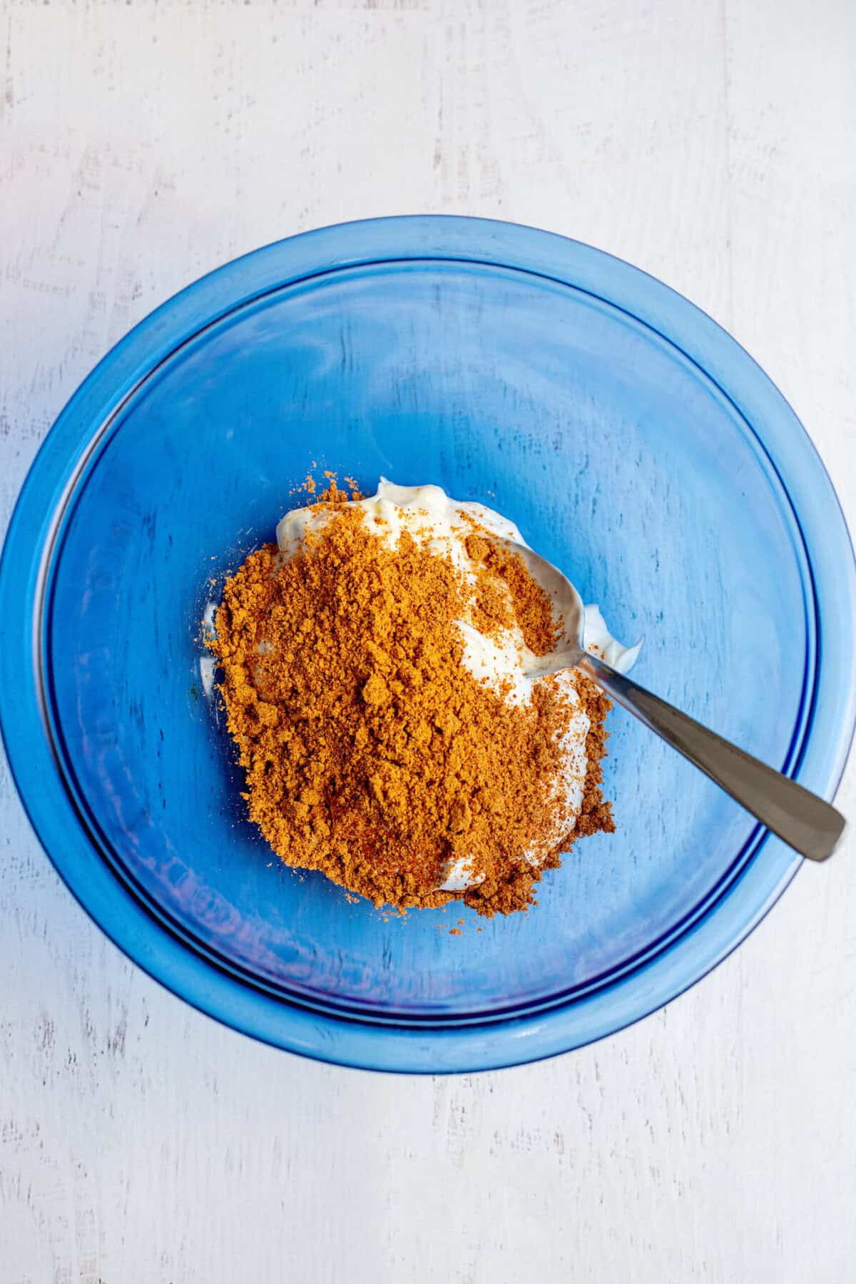 Spiced and sour cream in a glass blue bowl.