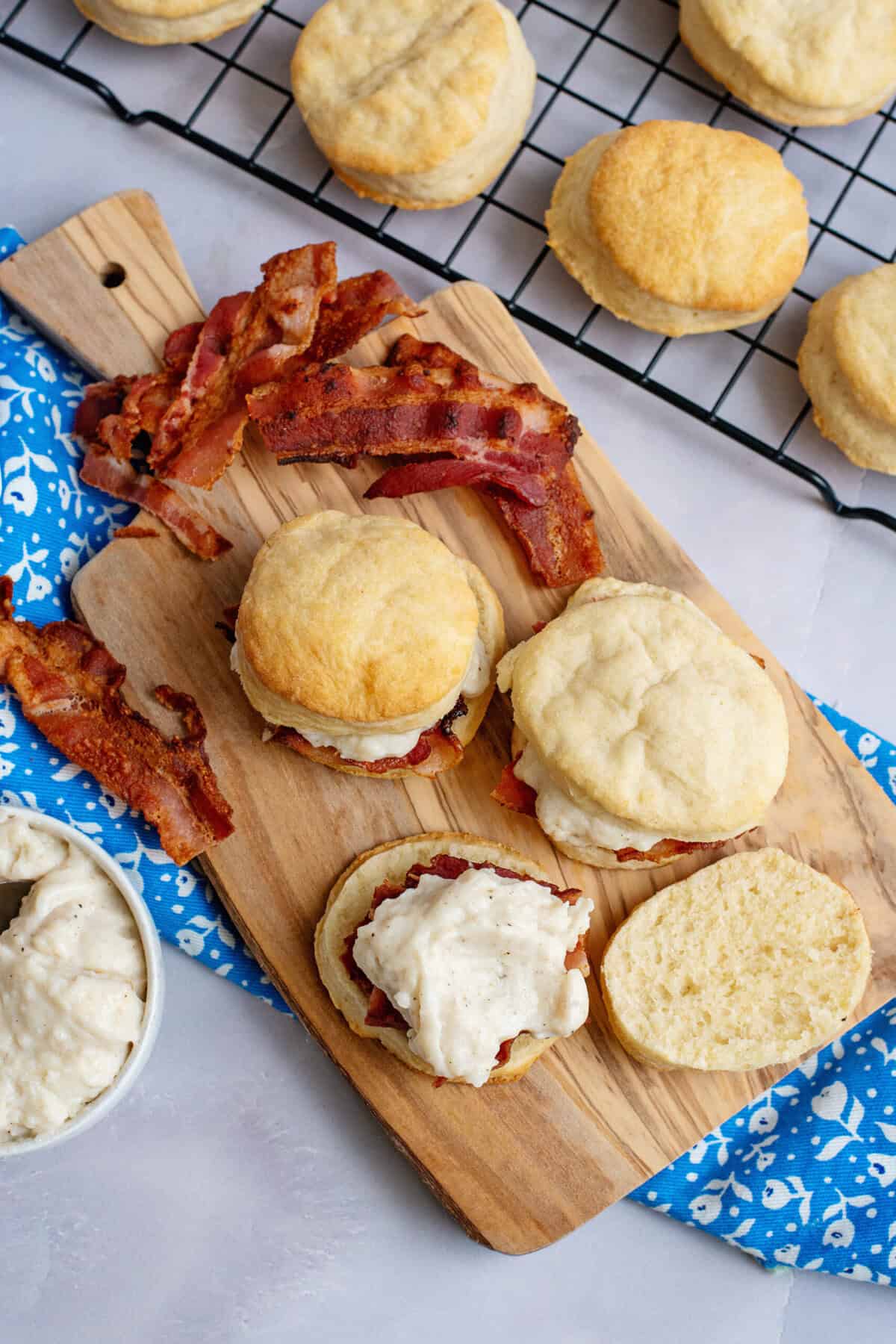 Assembling biscuits with bacon slices and bacon gravy.