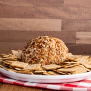 Cheese ball on plate with crackers.