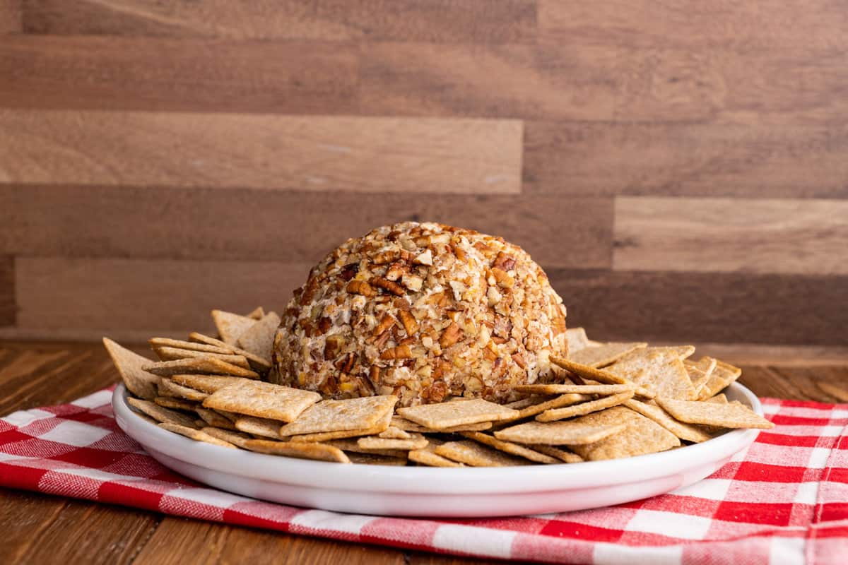 Cheese ball on plate with crackers.