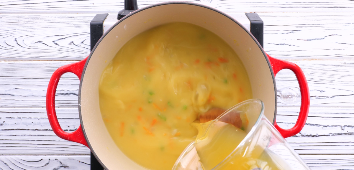 Adding chicken broth to saucepan.