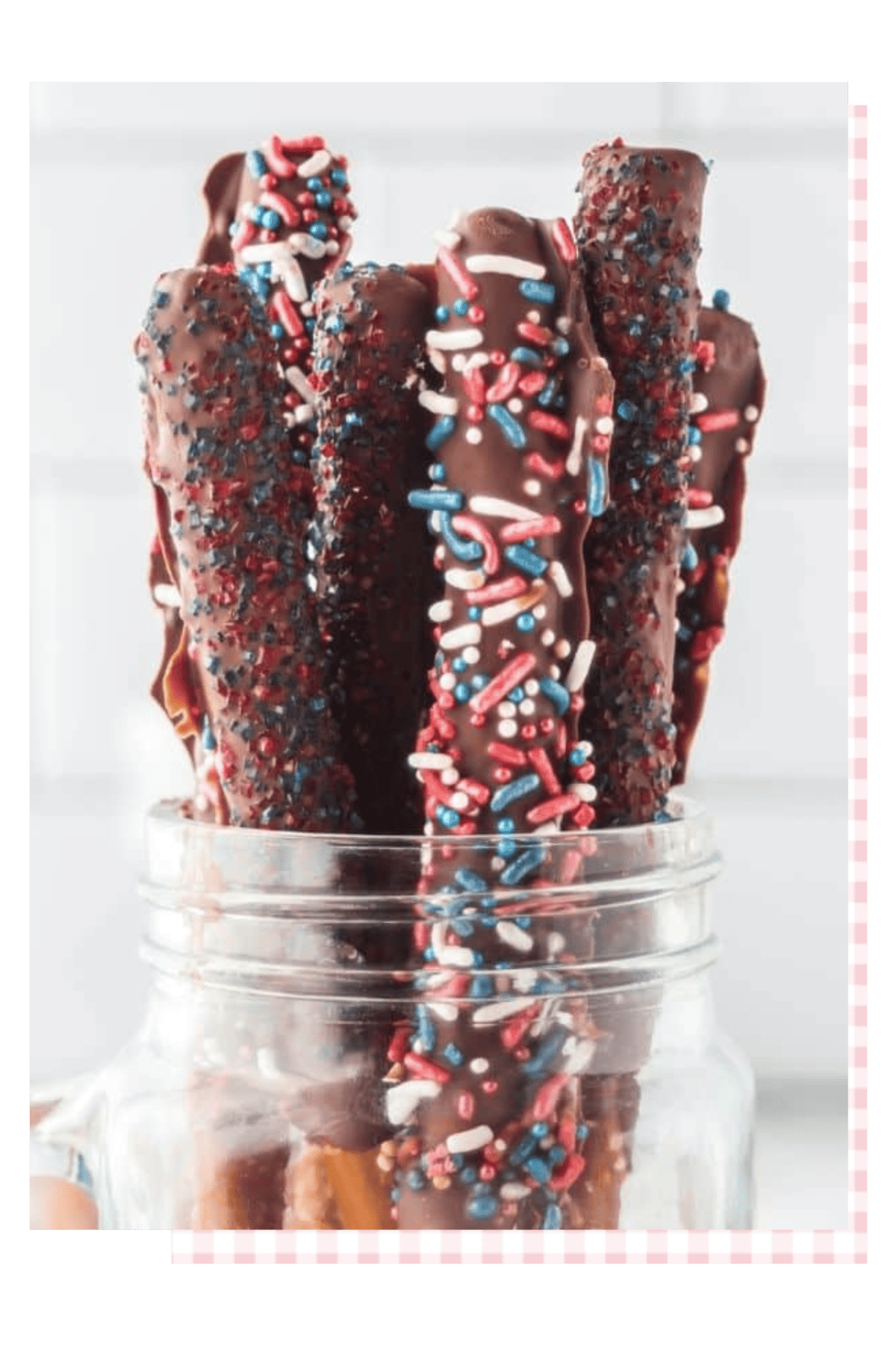Jar of chocolate dipped pretzels with red, white, and blue sprinkles.