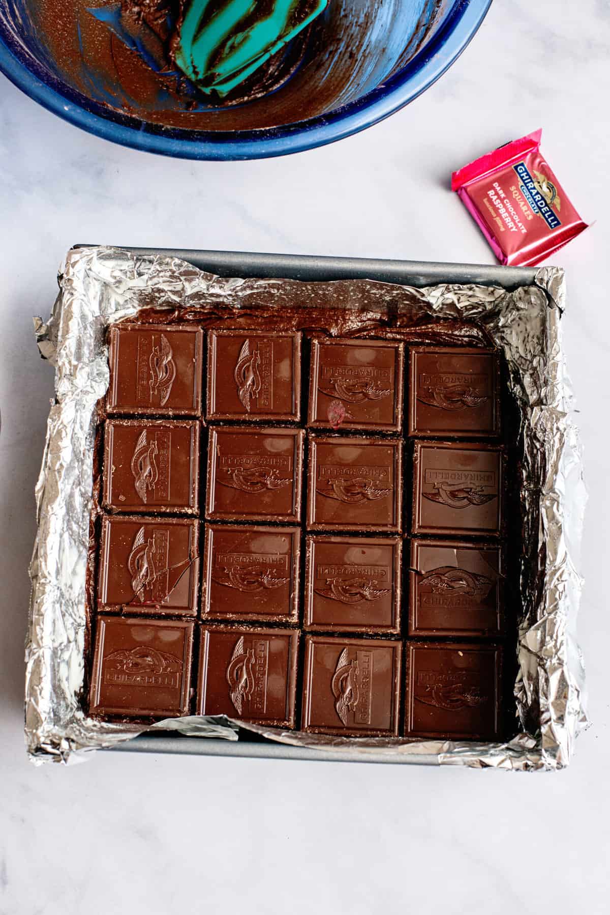 Line the brownie layer with the raspberry squares, covering the entire pan.