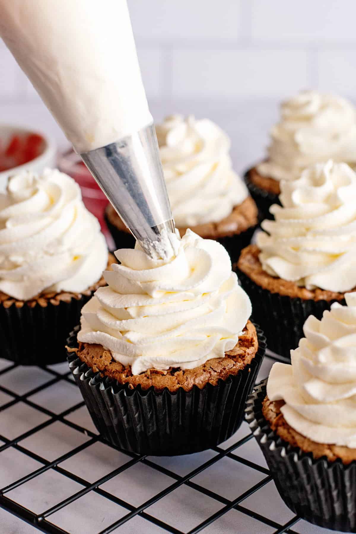 pipe frosting onto filled cupcakes 