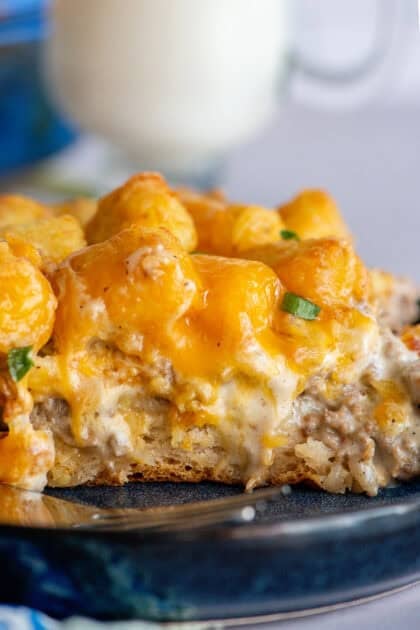 Biscuits and gravy tater tot casserole shown from the side with all its delicious layers.
