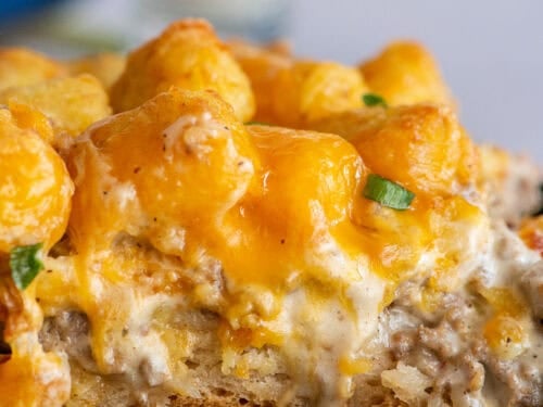 Biscuits and gravy tater tot casserole shown from the side with all its delicious layers.