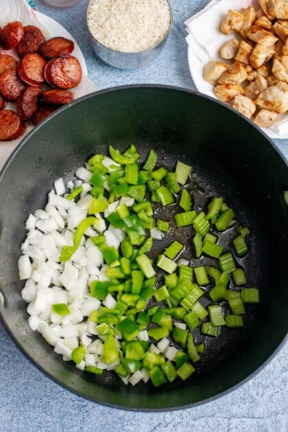 Diced onions, peppers, and celery in a skillet