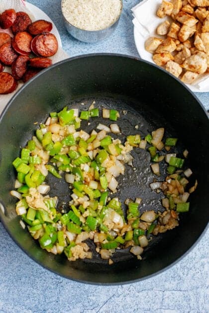 Onions, bell peppers, and celery frying in bacon grease.