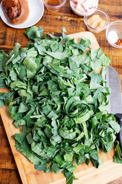 Freshly chopped collard greens on a cutting board.