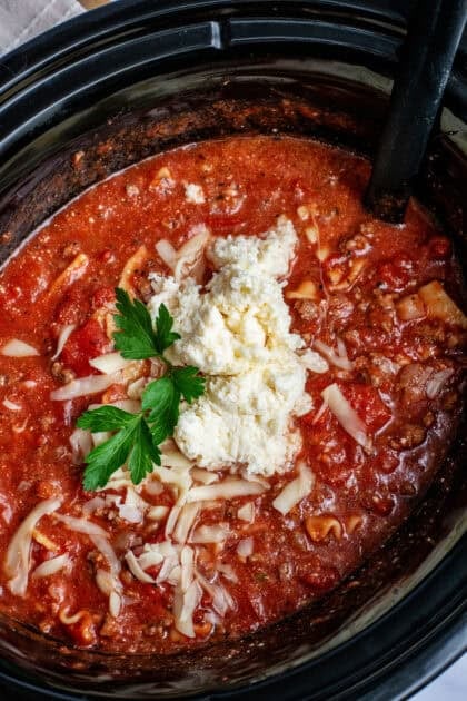 Lasagna soup in a crockpot with ricotta cheese on top.