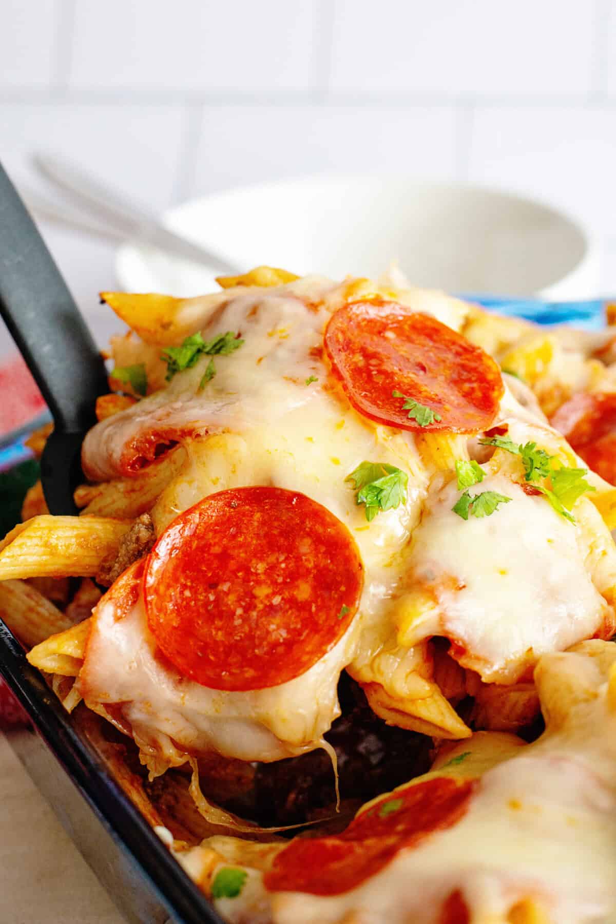 Close-up of pizza pasta casserole resting on a spatula.