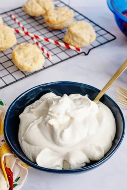 A bowl of whipped cream with soft peaks.