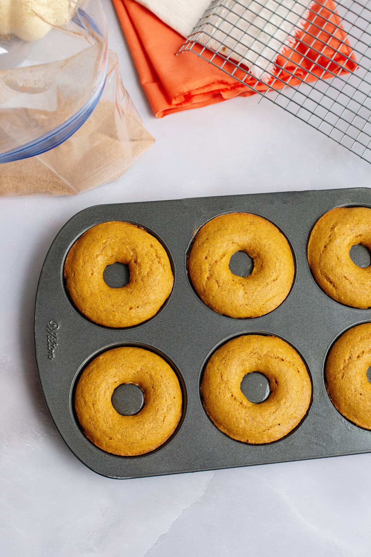 Pumpkin spice cake donuts fresh out of the oven in donut pan.