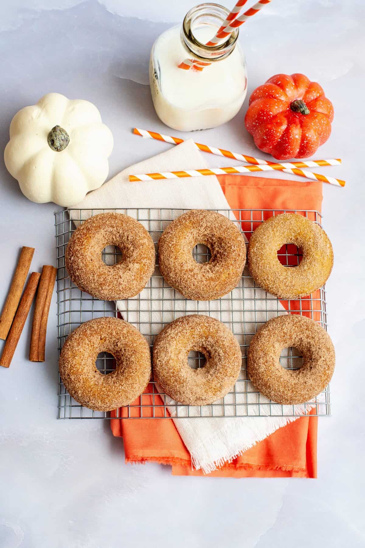 Pumpkin spice cake donuts on a cooling rack.