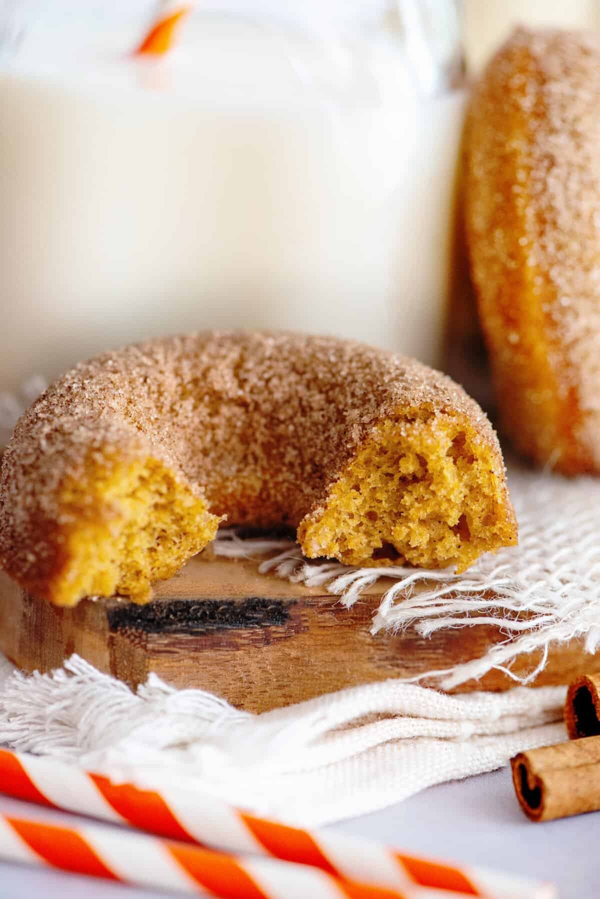 A bitten into pumpkin spice cake donut.