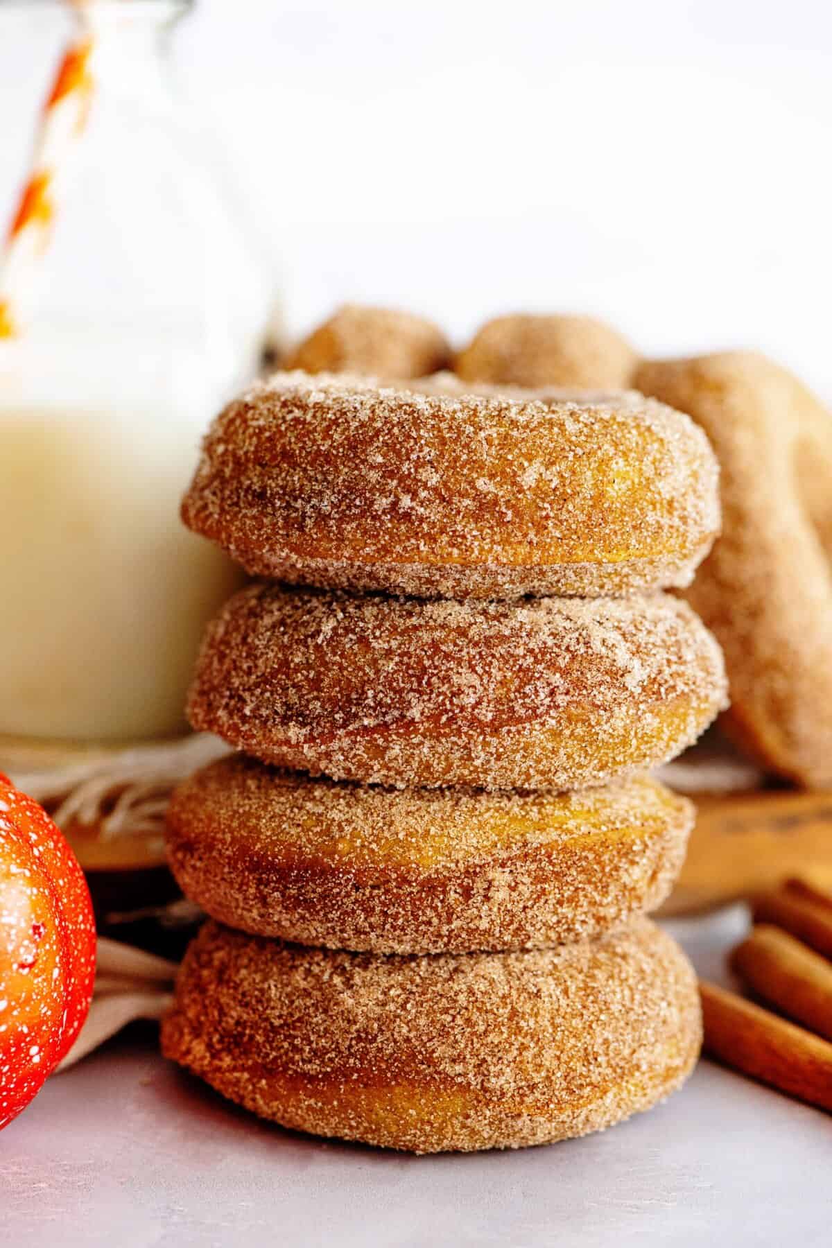 Stacked pumpkin spice cake donuts with a delicious cinnamon sugar coating.