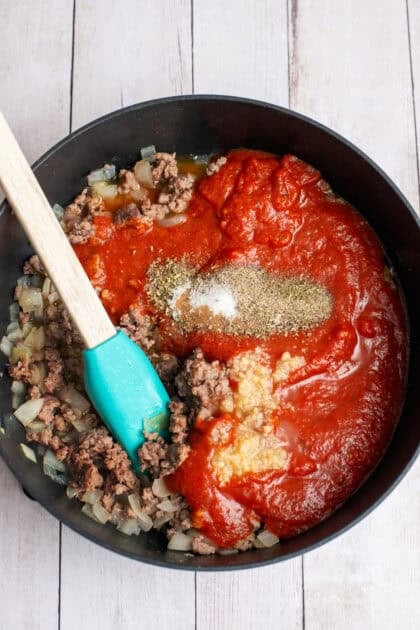 Hinzufügen der Nudelsauce zu goldenen Würstchen in einem großen Topf.