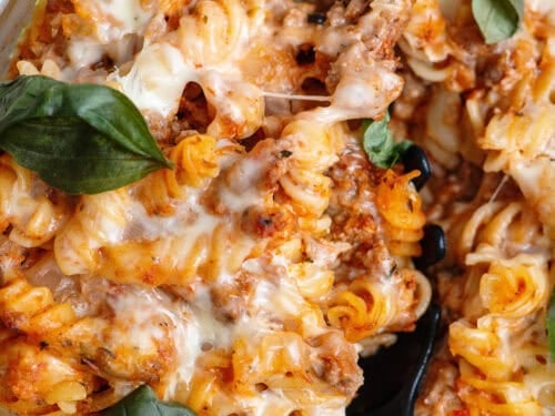 Close-up of a spoon scooping out a serving of Italian pasta bake.