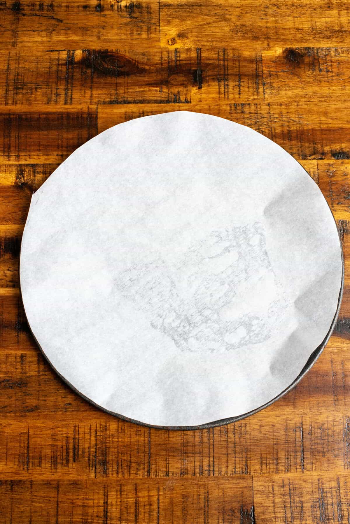 A pizza pan with parchment paper.