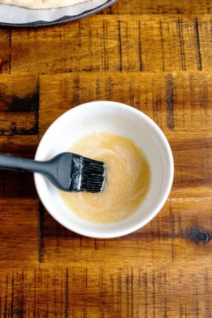 A small mixing bowl with melted better and maple syrup.