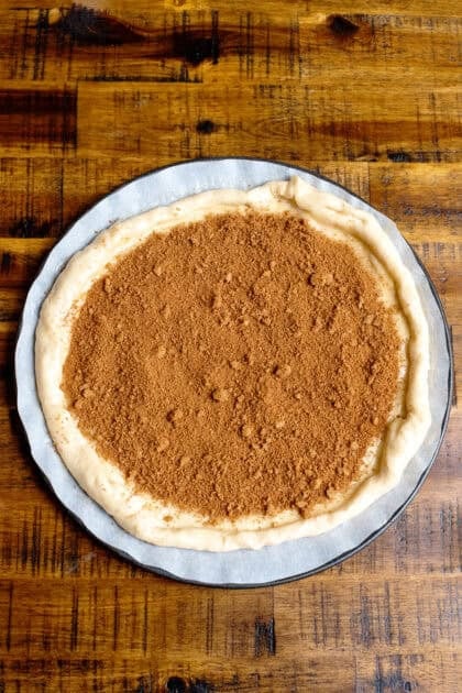 Cinnamon and brown sugar mixture spread evenly on rolled out crescent roll dough.