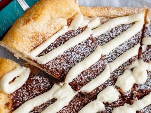 A spatula taking a slice of dessert pizza from the pizza pan.